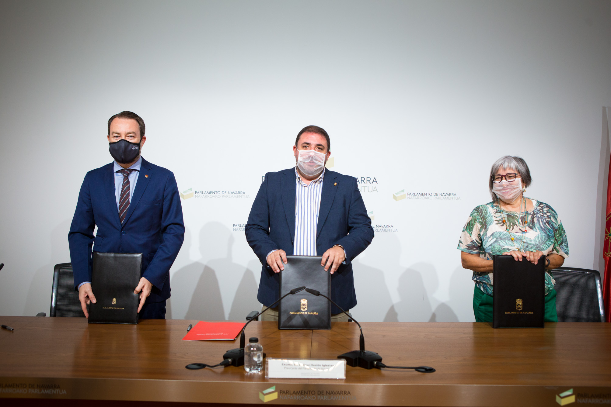 Fotografía de la presentación del Convenio en la que aparecen Ramón Gonzalo, rector de la UPNA, Unai Hualde, presidente del Parlamento de Navarra, y Mariluz Sanz, presidenta de CERMIN.