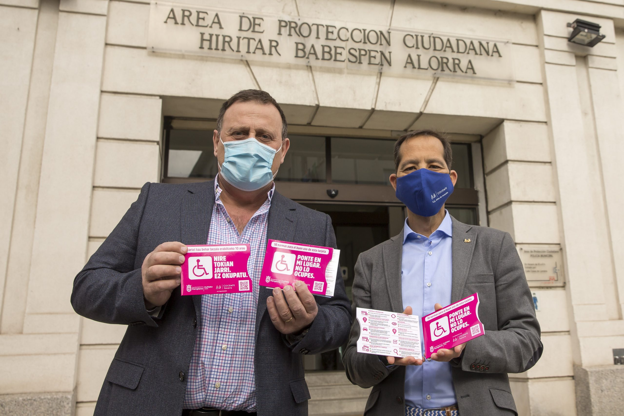 Javier Labairu y Manuel Arellano posan mostrando las fundas de las tarjetas de aparcamiento