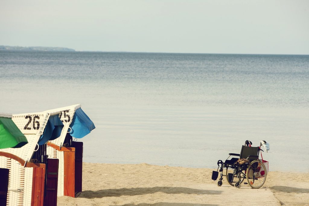 Imagen de una silla de ruedas sobre la arena de la playa