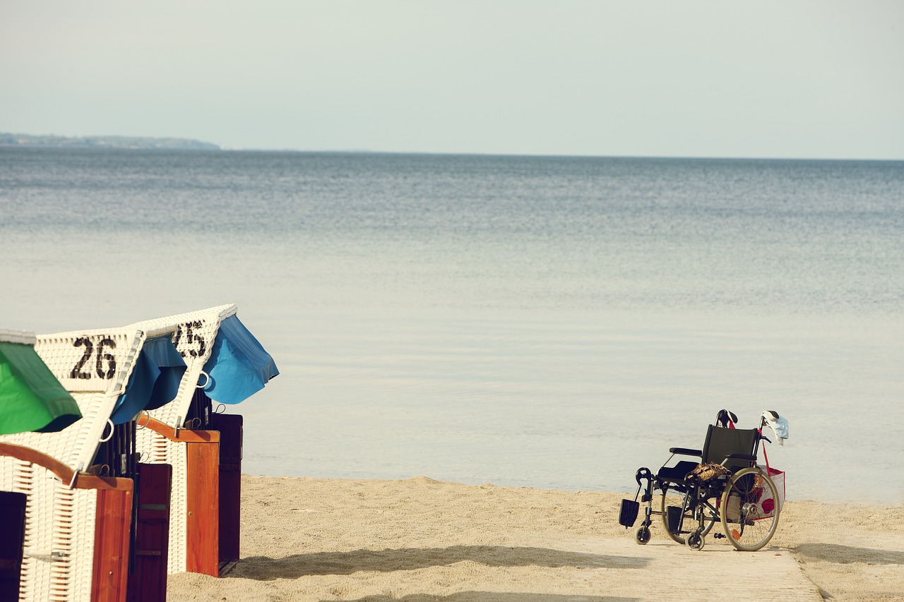 Imagen de una silla de ruedas sobre la arena de una playa