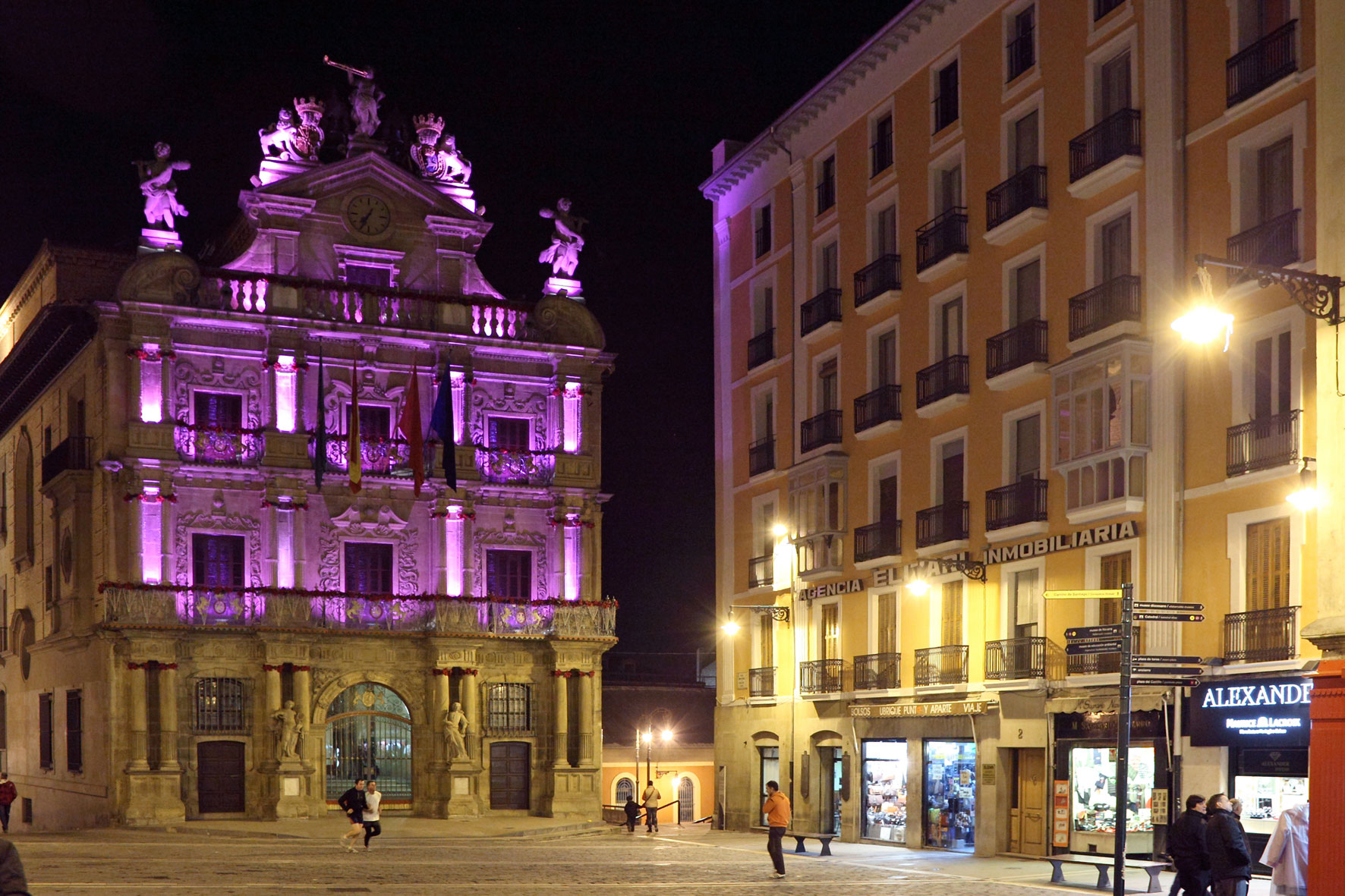 Imagen de la fachada del Ayuntamiento de Pamplona iluminada de color morado