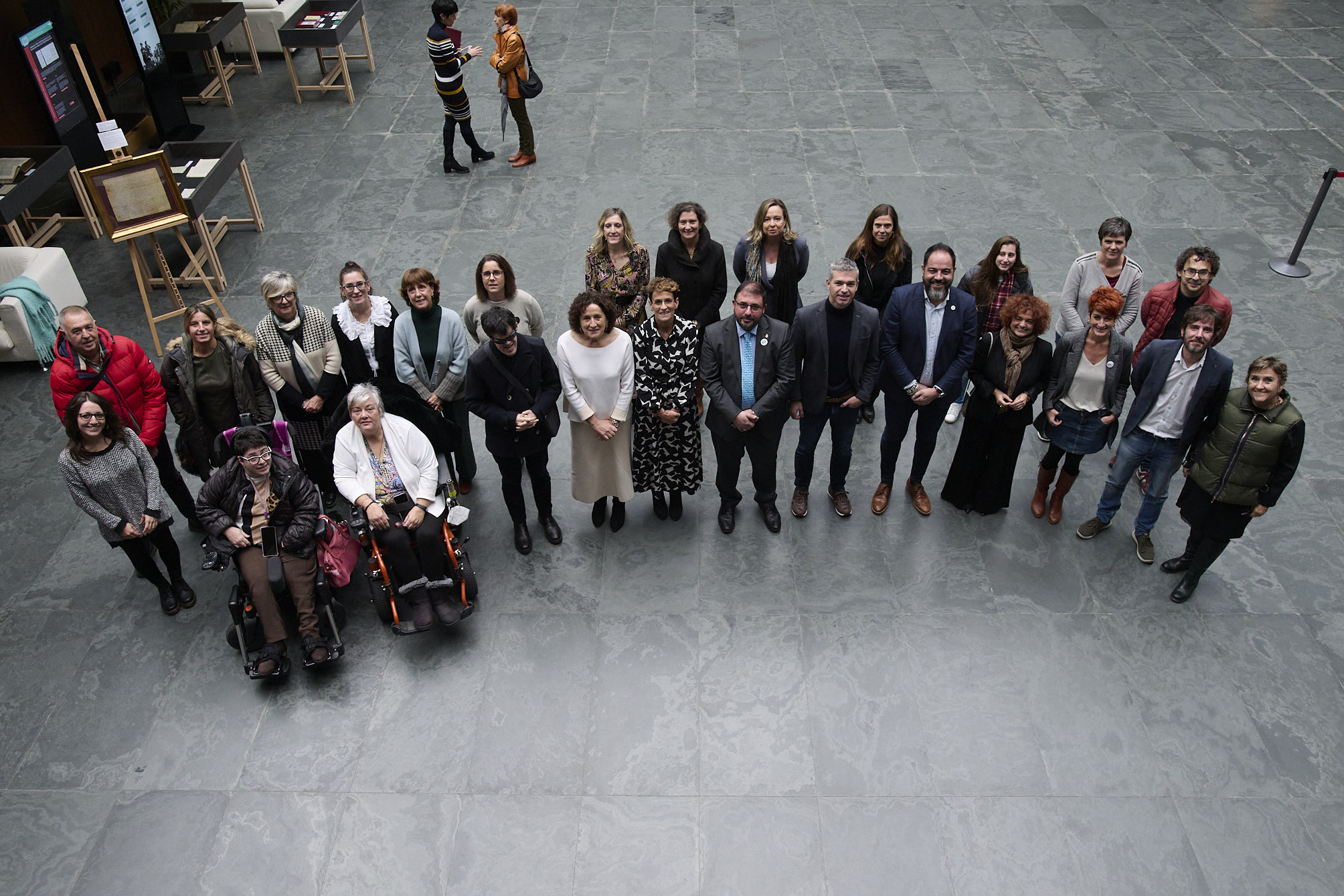 Fotografía de familia de integrantes de CERMIN junto con algunos parlamentarios en el atrio del Parlamento de Navarra