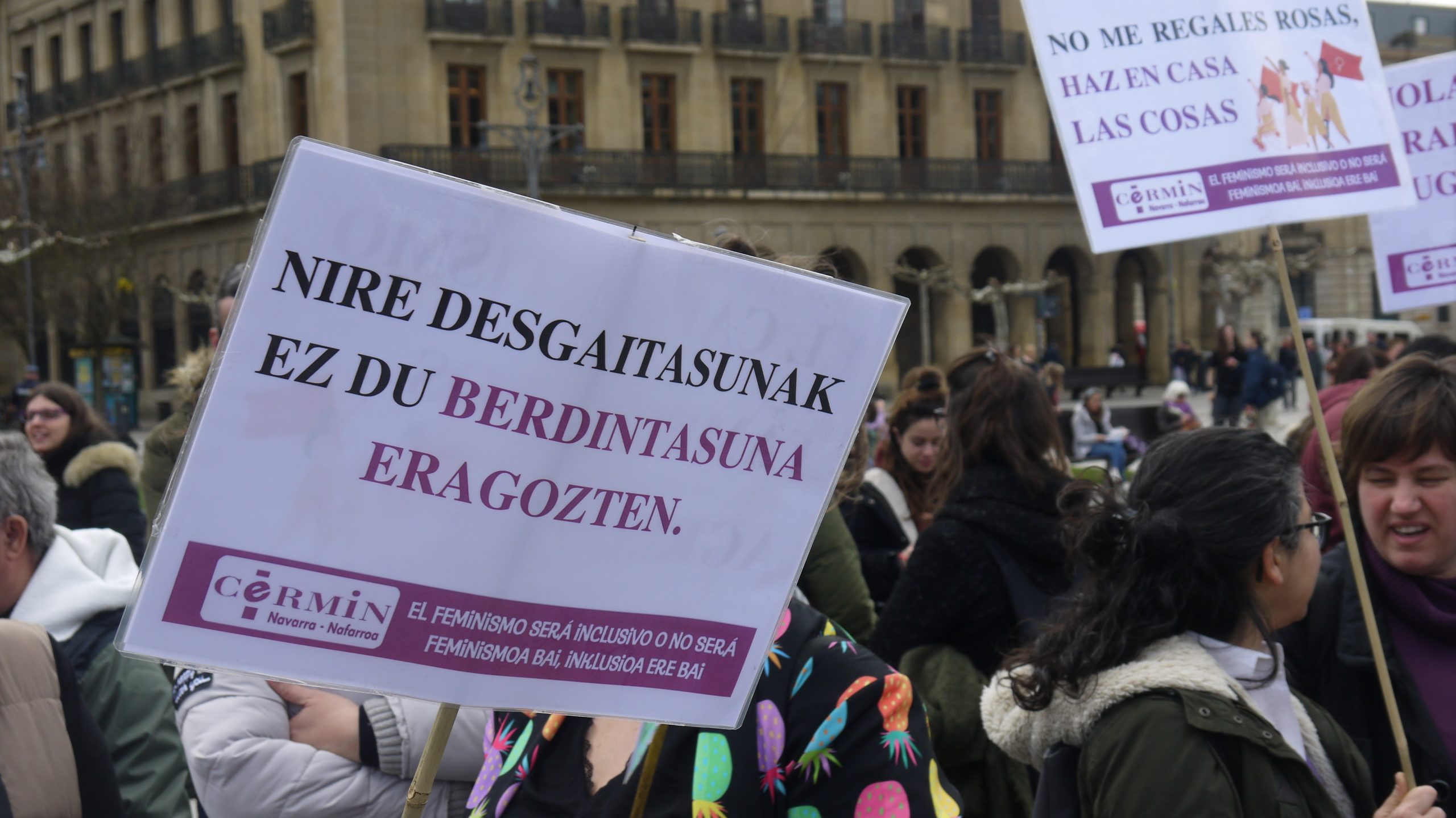 El primer cartel está en euskera y dice "mi discapacidad no impide la igualdad". El segundo está en castellano y dice: No me regales rosas, haz en casa las cosas. Ambos tienen el logo de CERMIN.