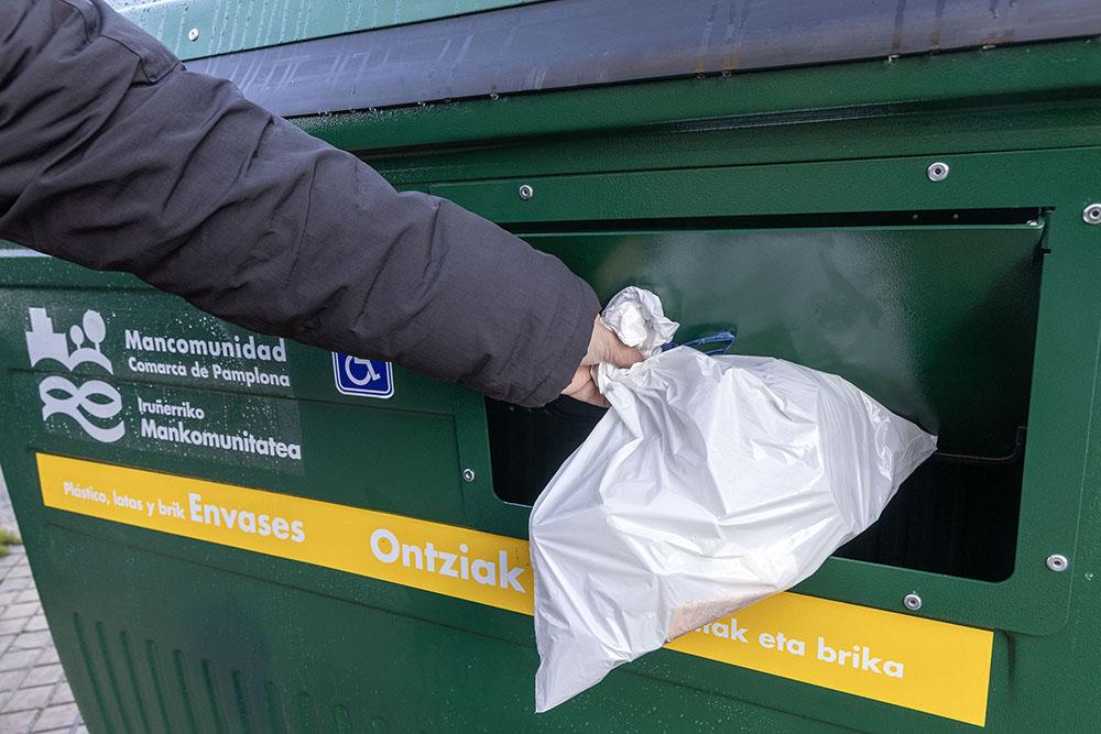 Ciudadano depositando residuos plásticos en un contenedor accesible