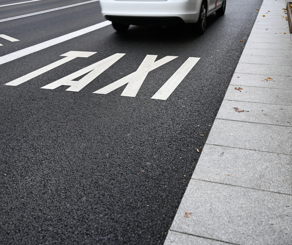 Fotografía de banco de imágenes donde se ve el asfalto con la indicación de taxi