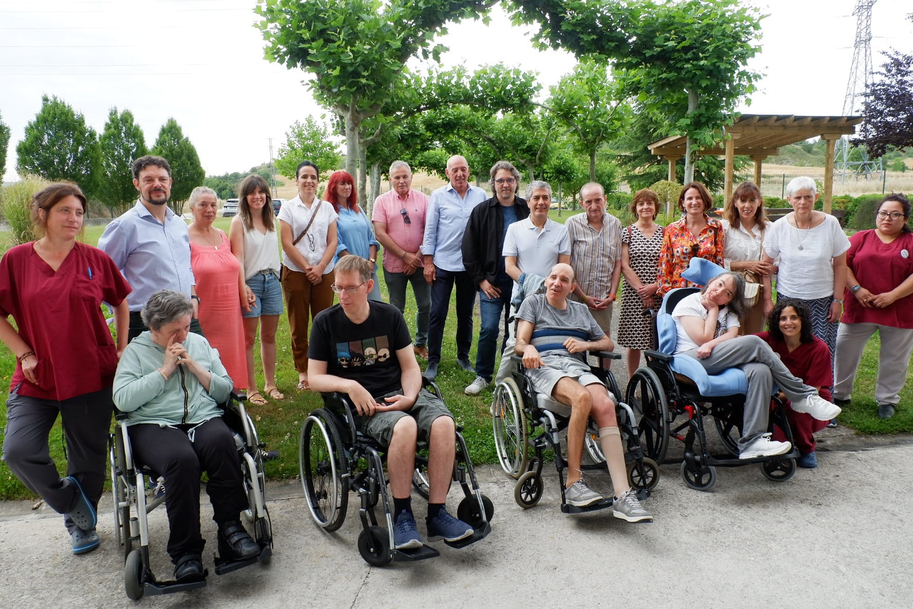 Fotografía de grupo de miembros del Parlamento de Navarra visitando ADACEN con usuarios/as de la entidad