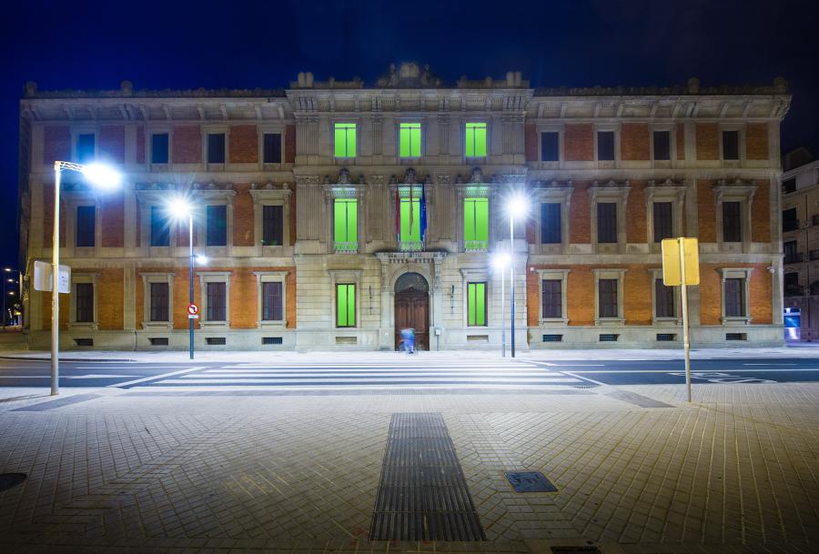 Fachada del parlamento de Navarra iluminada con luz verde