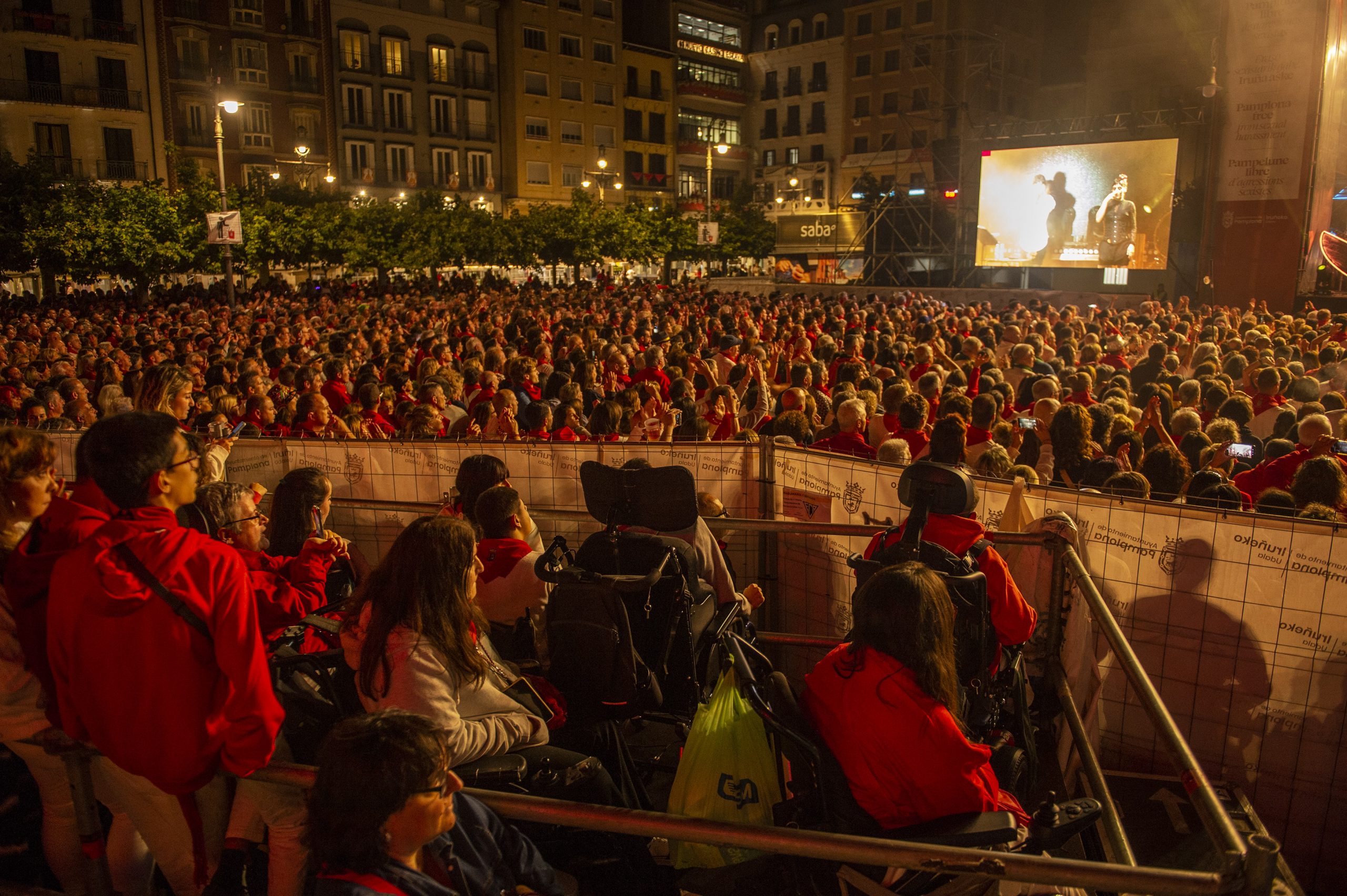 personas en sillas de ruedas disfrutando de los conciertos de Sanfermines en la Plaza del Castillo en la plataforma habilitado para ello.