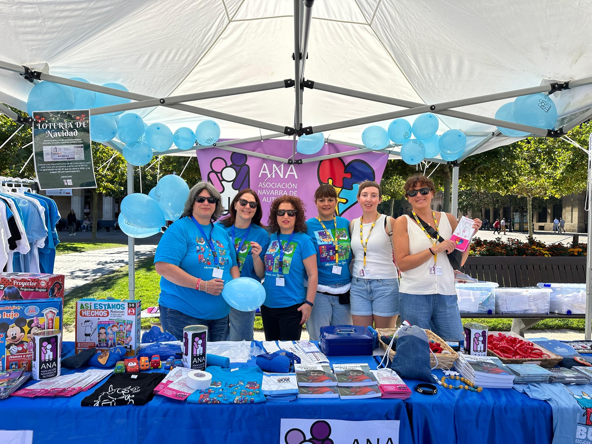 puesto de información de ANA AUTISMO con varias personas en una foto grupal