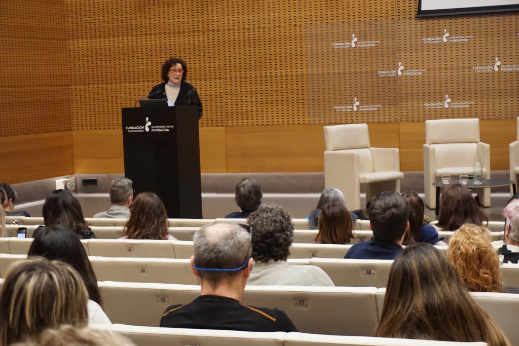 intervención de Carmen Maeztu. Se encuentra en el atril frente al público,