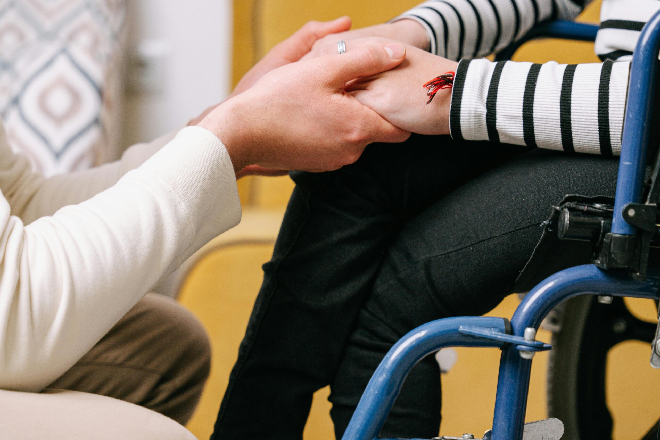 Manos persona cuando a otra que esta en una silla de ruedas.