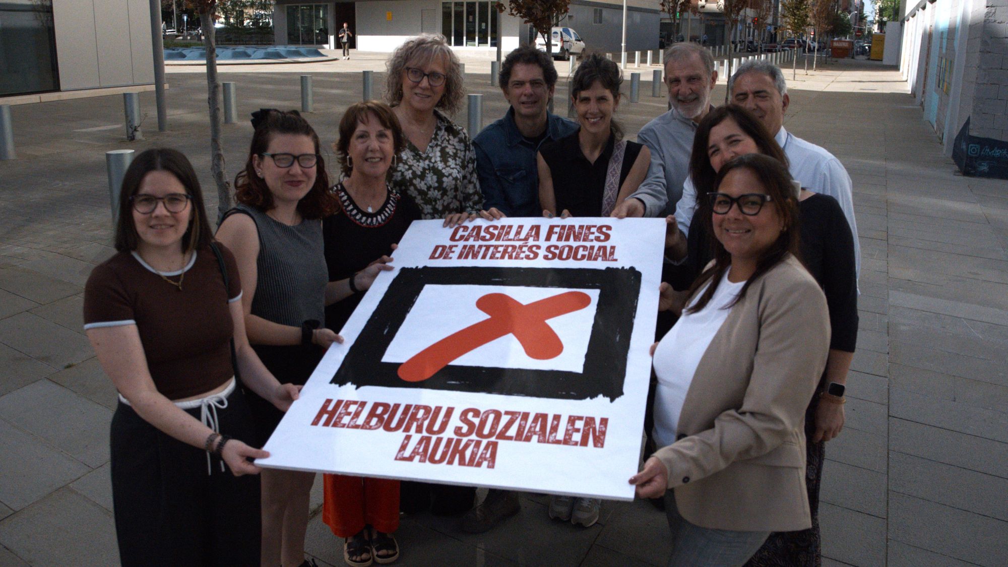 FOTOGRAFIA DE GRUPO SOSTENIENDO CARTEL DE LA X DE FINES DE INTERES SOCIAL