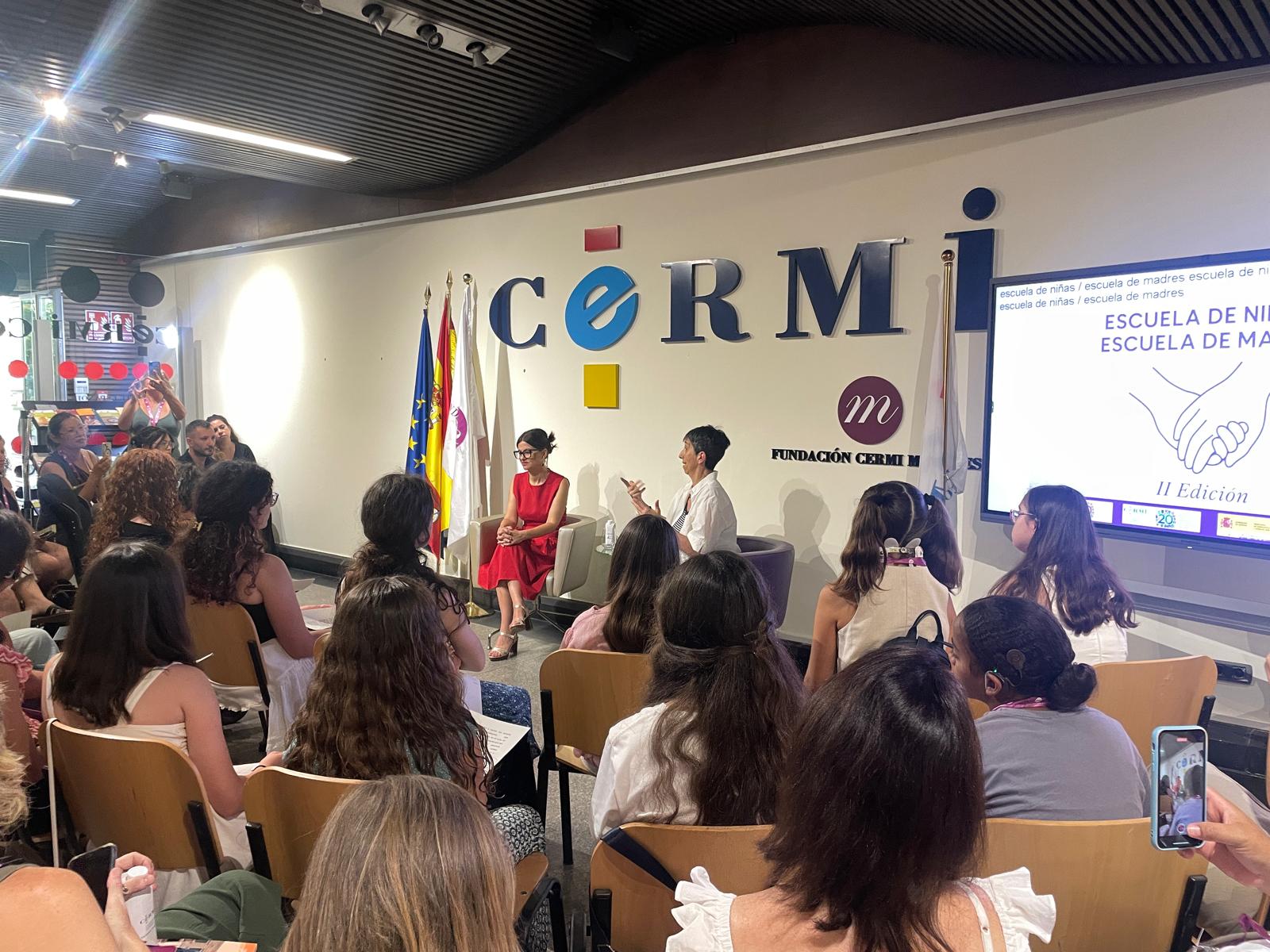 encuentro de escuela de niñas y madres de CERMIN. Asistentes se encuentran sentadas en semicirculo escuchando a la Ministra de Juventud de España
