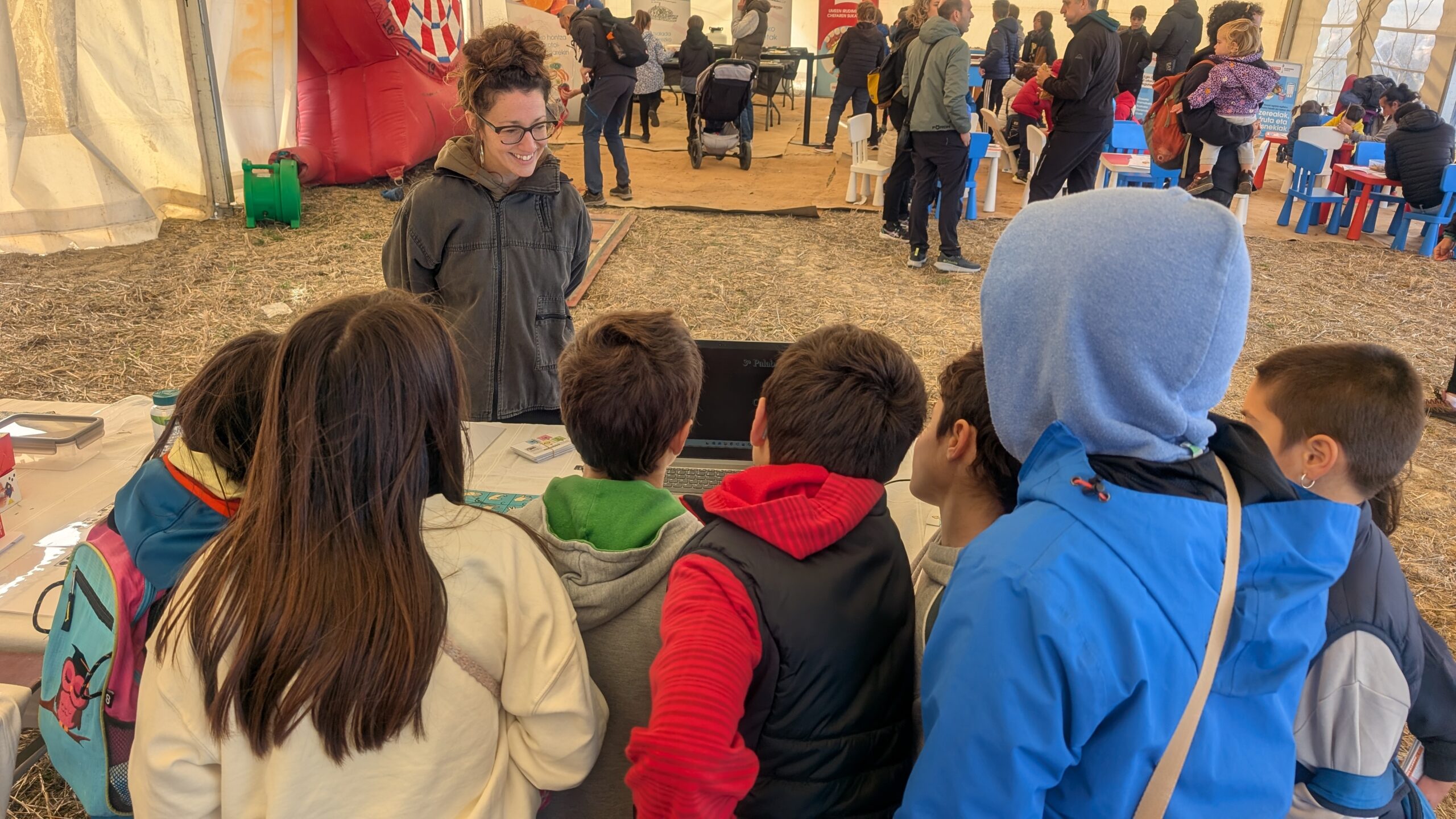 niños alrededor una mesa realizando una prueba de escucha. Delante de ellos está la técnica de CERMIN